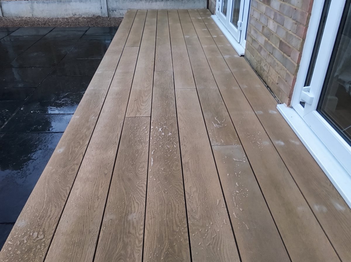 Composite decking boards laid along the back of a house