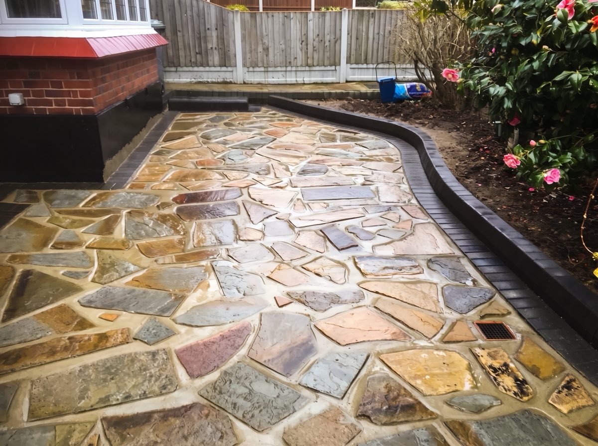 Finished crazy paving path with curved block edging beside the house