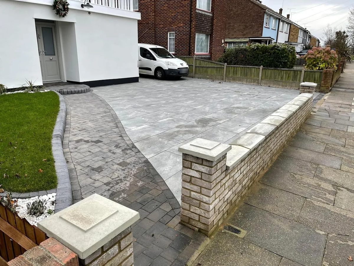 Grey porcelain driveway with a block-paved path and a new brick front wall with pier caps